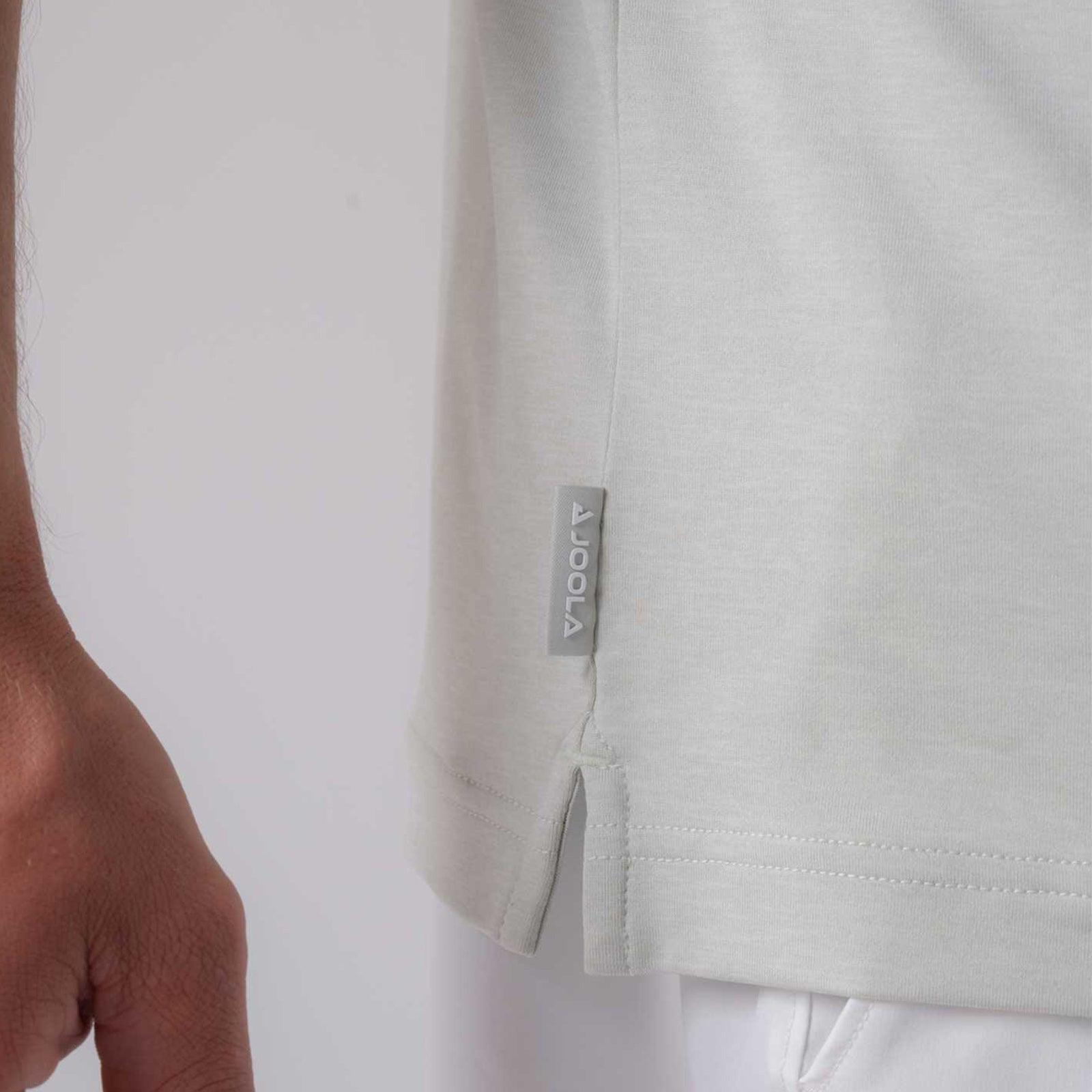 Detailaufnahme eines weißen T-Shirts mit kleinem Seitenschlitz und grauem JOOLA-Label am Saum.