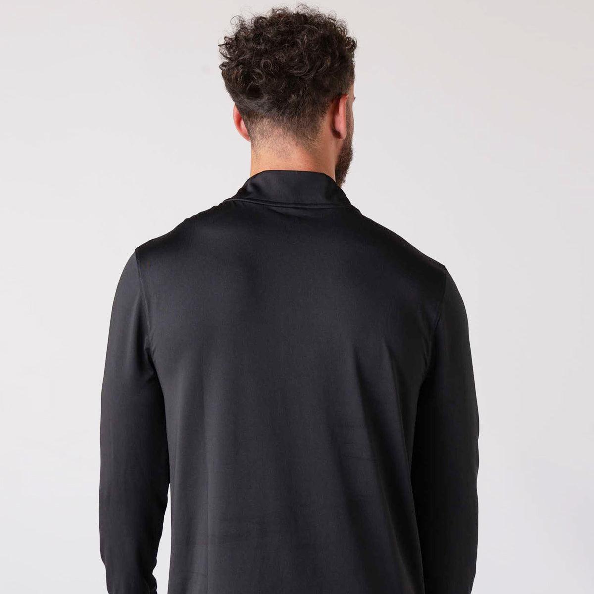 Mann von hinten mit schwarzem, langärmligem Oberteil vor hellem Hintergrund.