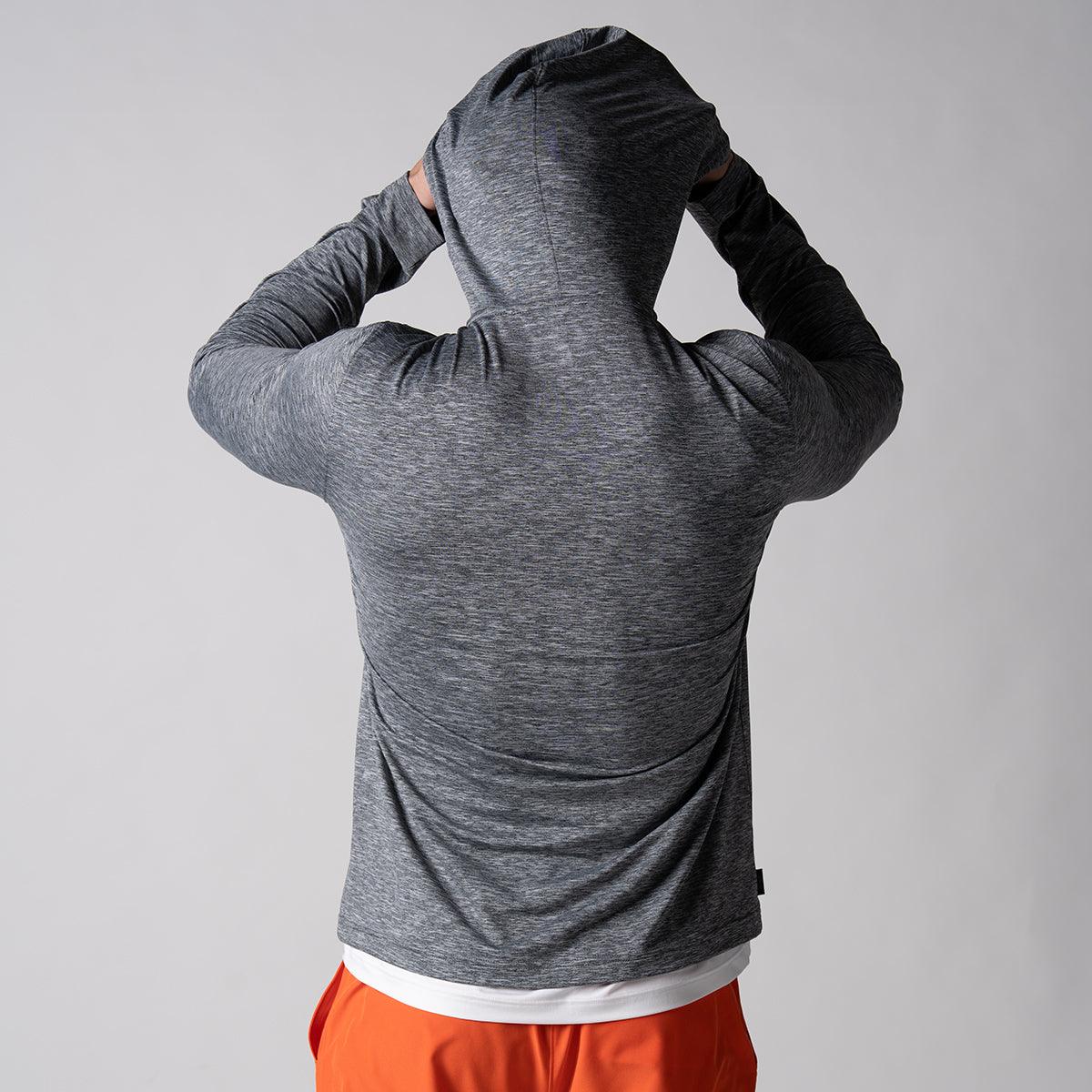 Mann von hinten mit grauem, langärmligem Hoodie und oranger Hose, Kapuze über den Kopf gezogen.