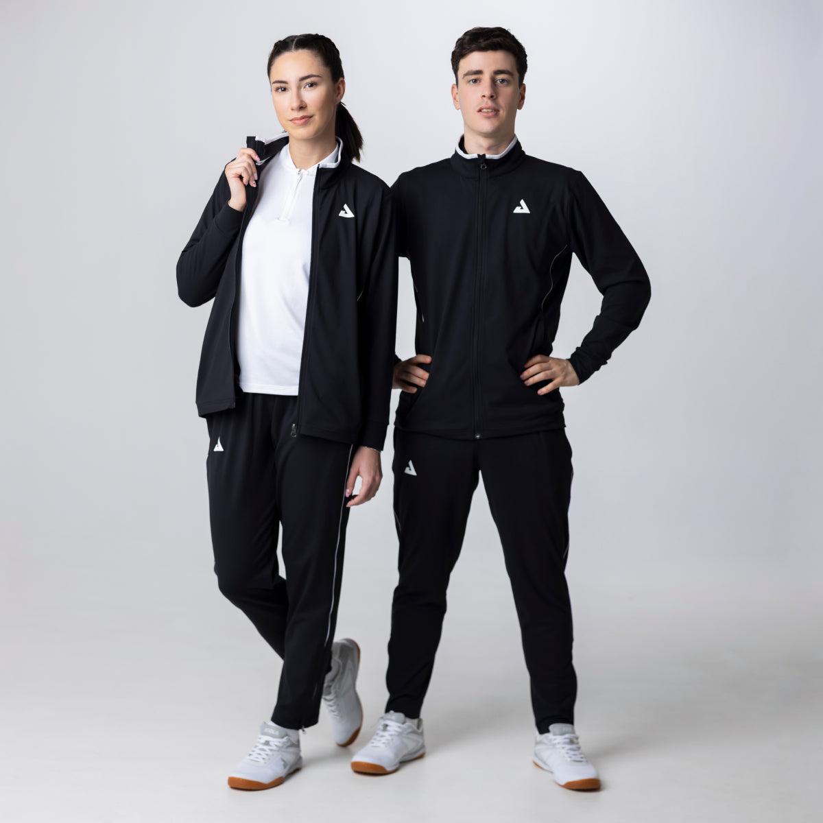 Zwei Models tragen schwarze Sportanzüge mit weißen Logos, weiße Sportschuhe und weiße Oberteile, vor hellgrauem Hintergrund.