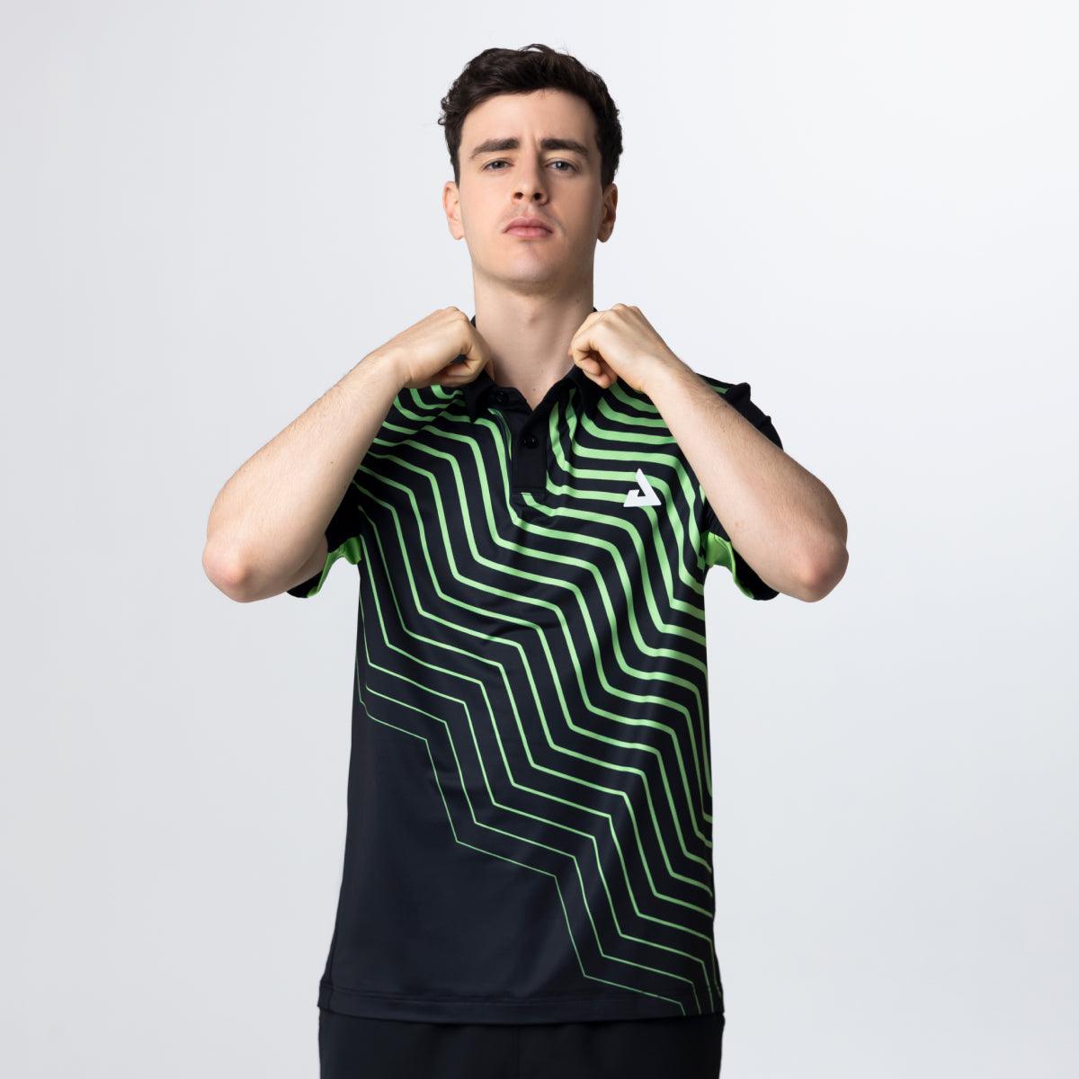 Mann trägt schwarzes Polo-Shirt mit grünem, geometrischem Linienmuster und Logo auf der Brust.