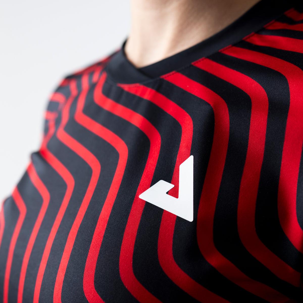 Nahaufnahme eines schwarzen und roten gestreiften Sportshirts mit weißem Logo auf der Brust.