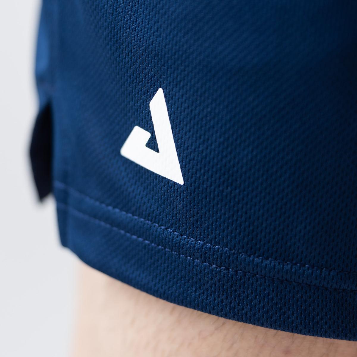 Nahaufnahme eines navyblauen Sportshorts mit weißem Logo am Saum.