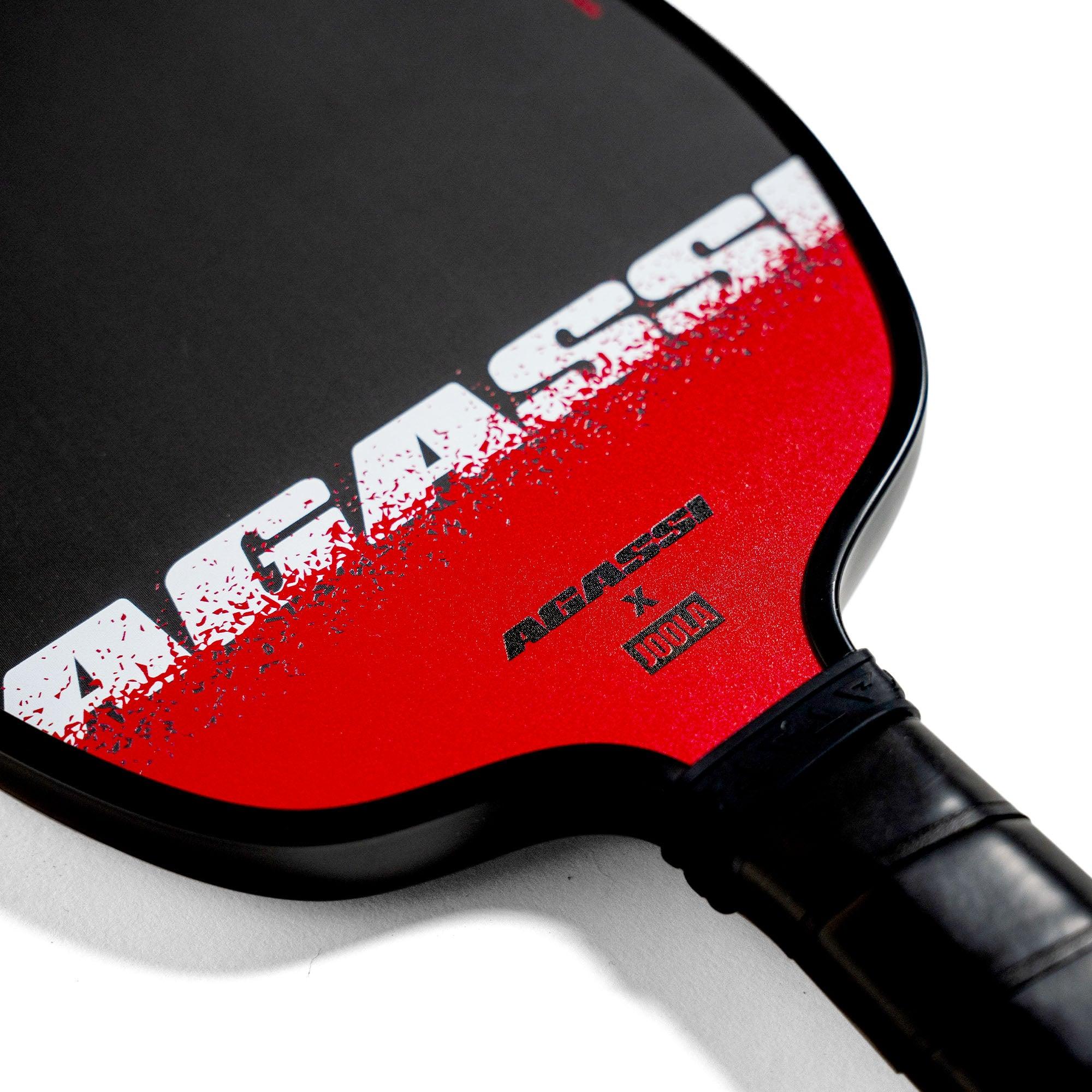 Schwarzer und roter Pickleball-Schläger mit der Aufschrift "AGASSI" und Logos von "AGASSI x JOOLA".